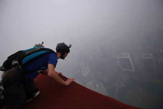 MALAYSIA, Kuala Lumpur: Base jumper 	Heavy haze didn't deter the 120 thrill-seeking base jumpers as they leapt into the foggy abyss off Kuala Lumpur Tower on October 3, 2015.  	The participants were joining others across the world on the 15th�International Base Jump Day. 