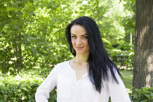European woman with black hair on green background