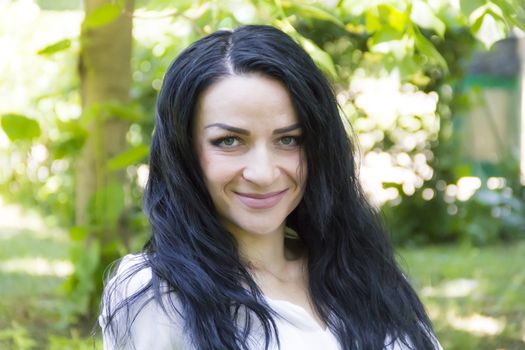 European woman with black hair on green background