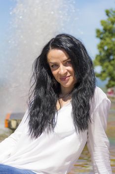 Photo of Caucasian brunette woman on fountain background