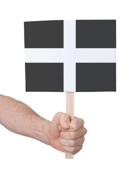 Hand holding small card, isolated on white - Flag of Cornwall