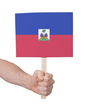 Hand holding small card, isolated on white - Flag of Haiti