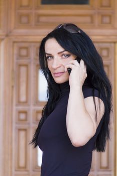 Photo of Caucasian brunette talking by cellular