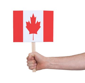 Hand holding small card, isolated on white - Flag of Canada