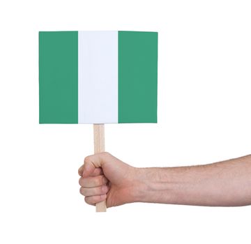 Hand holding small card, isolated on white - Flag of Nigeria