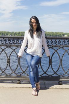 Standing young Caucasian woman on river background