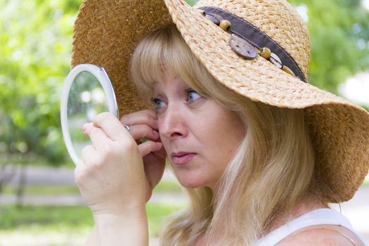 European blond woman looking in the mirror