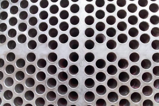 Steel plate with rough surface and drilled holes. Steel pipes connected to the holes on the back side.