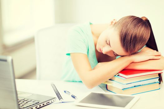 education and technology concept - tired student sleeping on stack of books