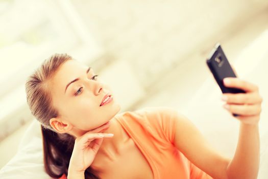 technology concept - woman making self portrait with smartphone