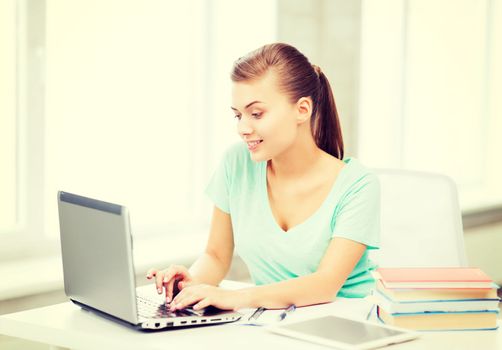 education, technology and internet concept - smiling student girl with laptop