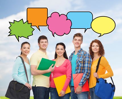 school, education, communication and people concept - group of smiling teenagers with folders and school bags over blue sky and grass background with doodles