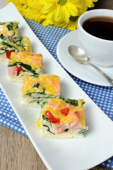 Canape of omelet with spinach, sausage and a cup of coffee