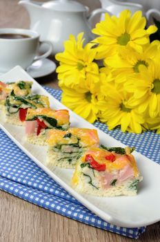 Canape of omelet with spinach, sausage and a cup of coffee