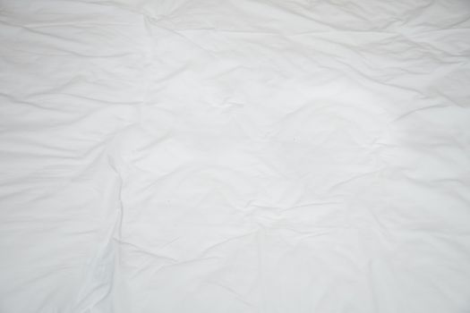 Old rumpled bed sheet with creases. View from above