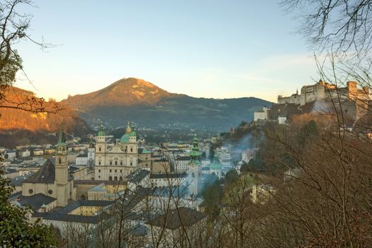 Old town of Salzburg dominated by old church buildings with tall towers and domes - famous Hohensalzburg Fortress on the right, Salzburger Land, Austria