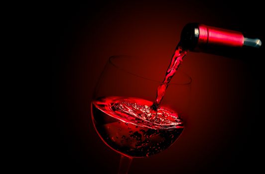 barman pouring red wine in the glass on red gradient background