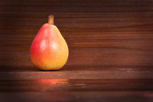 In the picture one pear  "Angelica" Typical Italian, placed on wooden boards brown and empty space on the right.