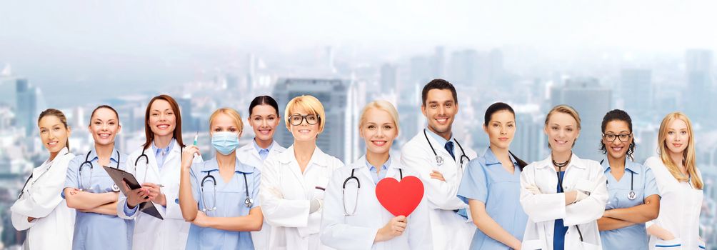 healthcare and medicine concept - smiling doctors and nurses with red heart