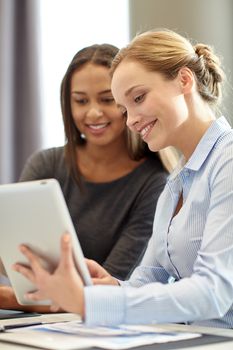 business, people and technology concept - smiling businesswomen with tablet pc computer meeting in office