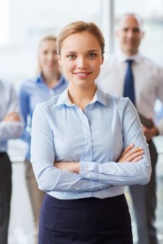 business, people and teamwork concept - smiling businesswoman with group of businesspeople in office