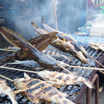 Grilling fish in Sangklaburi market, Kanchanaburi, Thailand