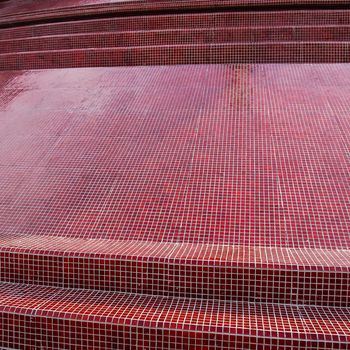 Kanchanaburi, Thailand - March 5, 2011 : Glossy red small tiles decorated on surface of the pagoda of Sunanthawararam Temple