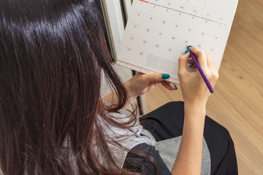woman holding pencil on calendar for  making appointment  important day