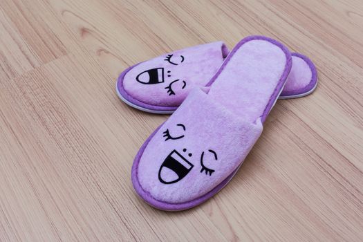 smile slippers and happy, close up view, on wooden floor