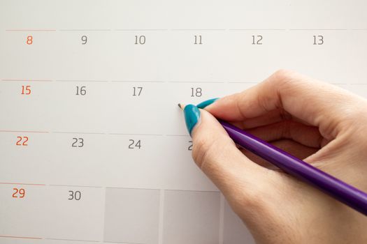 hand holding pencil on calendar for  making appointment  important day