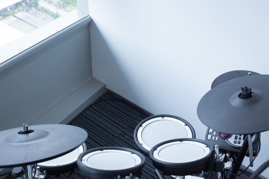Electronic drum set in the room corner as musical background technology theme