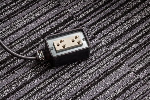 Electrical socket with power plug cable on carpet floor for safety concept
