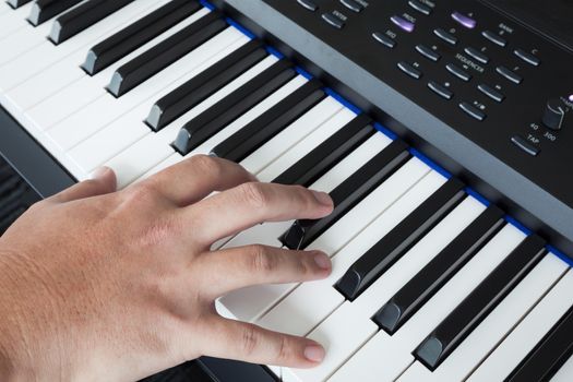hand on Piano Keyboard synthesizer closeup key frontal view