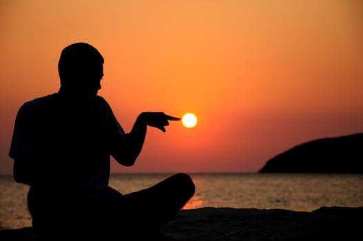 silhouette of an young man on sunrise and sea on background