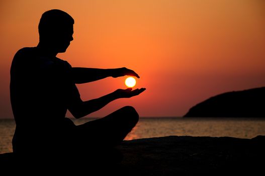 silhouette of an young man on sunrise and sea on background