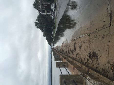 UNITED-STATES, Charleston : A rain water puddle overflows a road when catastrophic floods ravaged much of South Carolina on October 4, 2015. Heavy rains dropped nearly 17 inches on the state capital of Charleston in a 17 hour span. At least nine people died in South Carolina as a result of the flooding and one person has died in neighboring North Carolina. The storms also left some 30,000 residents without power and shut down many major roads. Governor Nikki Haley called the rains the worst in 1,000 years. 