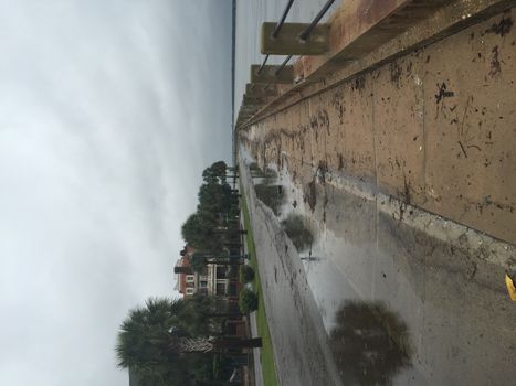 UNITED-STATES, Charleston : A rain water puddle overflows a road when catastrophic floods ravaged much of South Carolina on October 4, 2015. Heavy rains dropped nearly 17 inches on the state capital of Charleston in a 17 hour span. At least nine people died in South Carolina as a result of the flooding and one person has died in neighboring North Carolina. The storms also left some 30,000 residents without power and shut down many major roads. Governor Nikki Haley called the rains the worst in 1,000 years. 