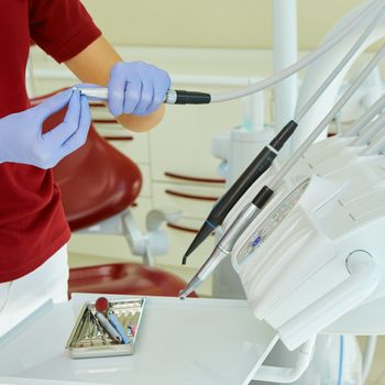 hands of dentist holding his tools during patient examination