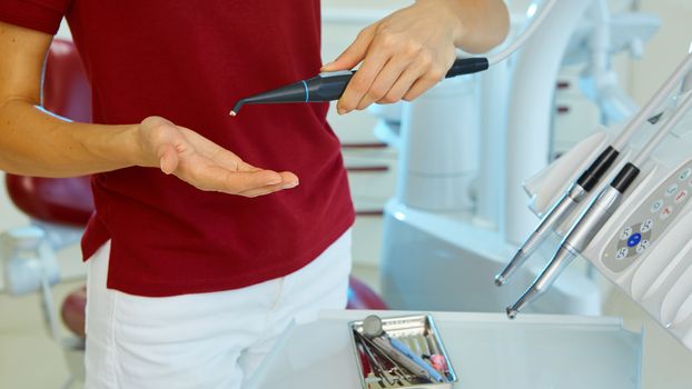 hands of dentist holding his tools during patient examination