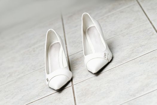 Photo of the white wedding shoes on the floor