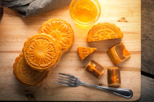 Moon cake, Chinese mid autumn festival dessert on wood board with dramatic morning scene