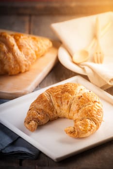 Whole wheat croissant on ceramic dish with morning scene