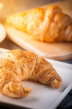 Whole wheat croissant on ceramic dish with morning scene