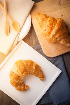 Whole wheat croissant on ceramic dish with morning scene