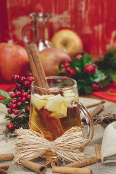 Sparkling Apple Cider with cinnamon and an apple slice on wooden table, festive decoration