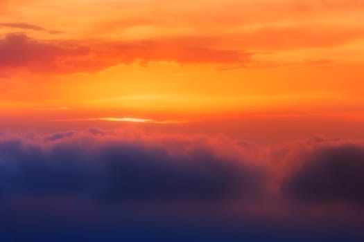 Brilliant orange sunset over clouds. Suitable for background