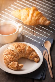 Butter croissant and whole wheat croissant with a cup of hot chocolate on wood table with morning scene