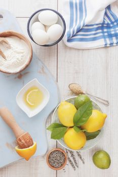 Ingredients for lemon cake on wooden table, vintage style, top view. Natural light