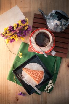 Top view of Thai tea cake on black ceramic dish with a cup of hot tea with afternoon scene