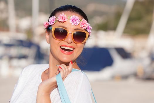 Happy woman walking with bag and enjoying sunny day at marina